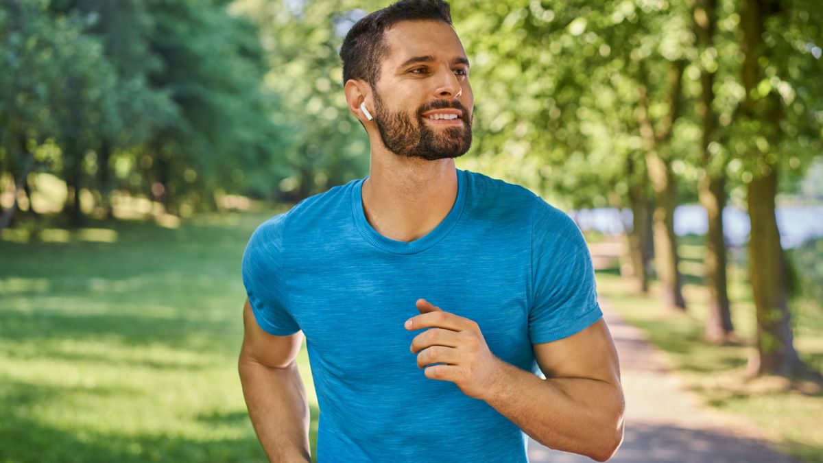 Man running in park with headphones