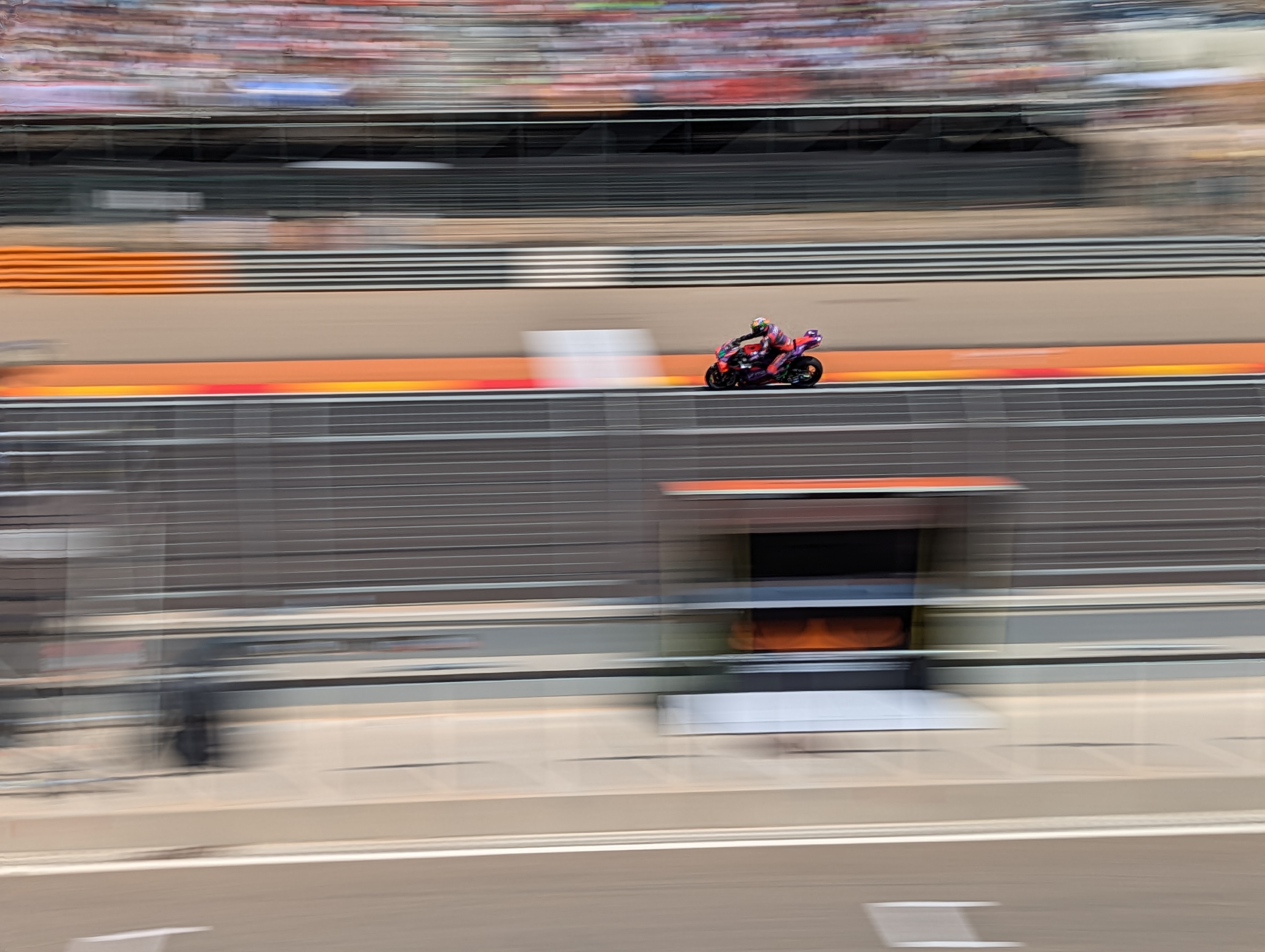 MotoGP riders at full speed on racetrack with action panning photography technique accentuating movement