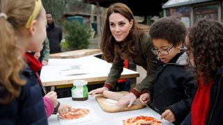 Catherine, Princess of Wales speaks with children and helps makes pizza as she visits Islington Community Garden on January 15, 2019