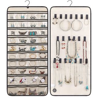 a dual-sided organizer has clear pockets on one side, and black loops on the other holding jewelry