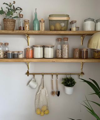wooden shelving unit with food containers and hanging rails