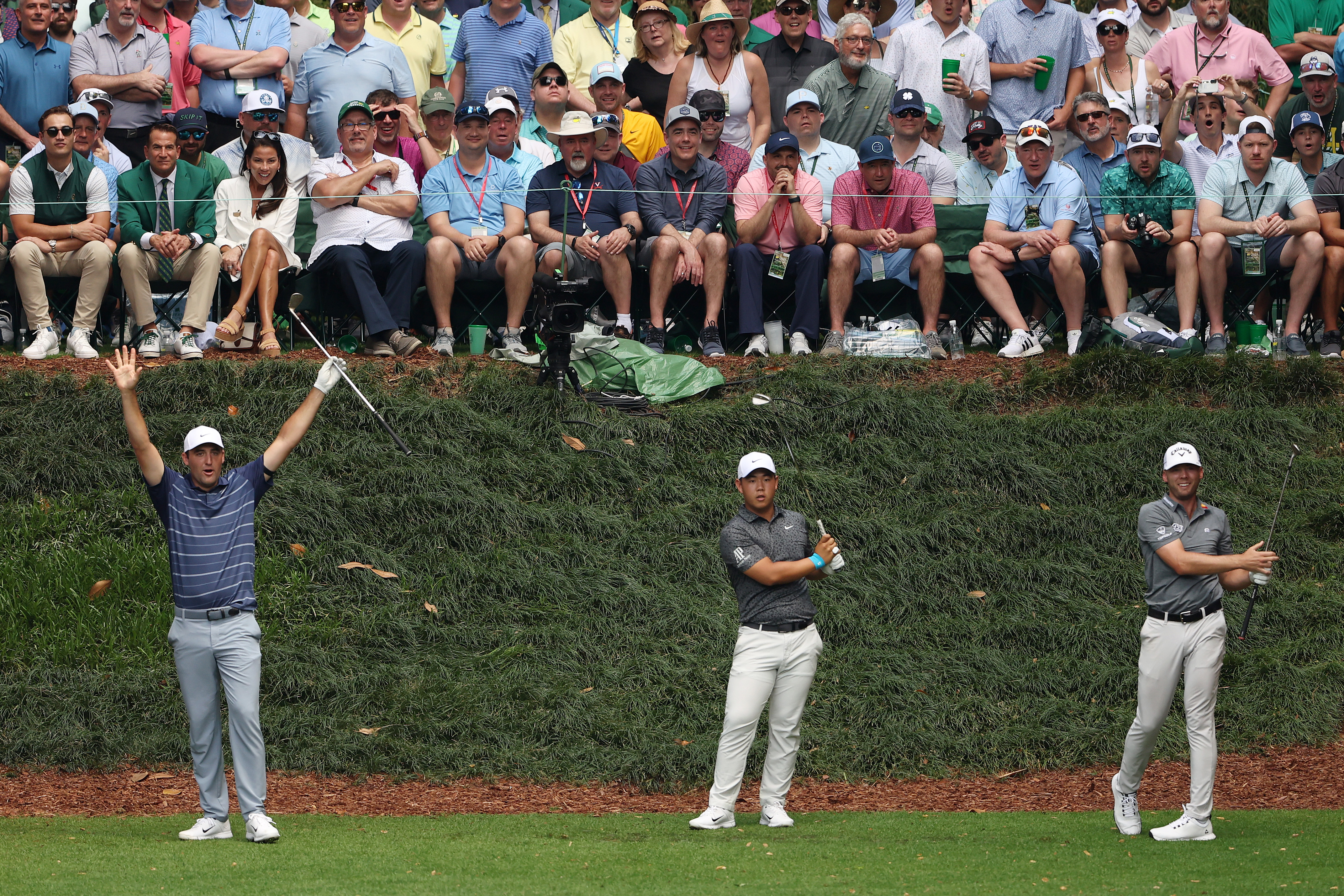Three golfers celebrate after a hole-in-one