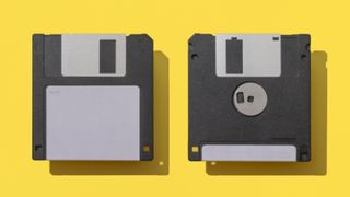Close-Up Of Two Floppy Disks Against Yellow Background