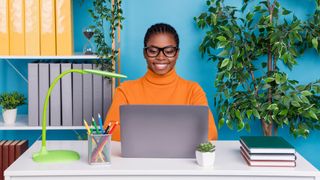 Woman using a laptop in a bright blue office 