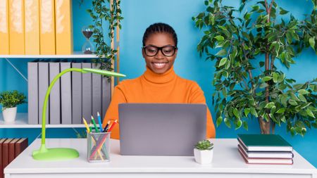 Woman using a laptop in a bright blue office