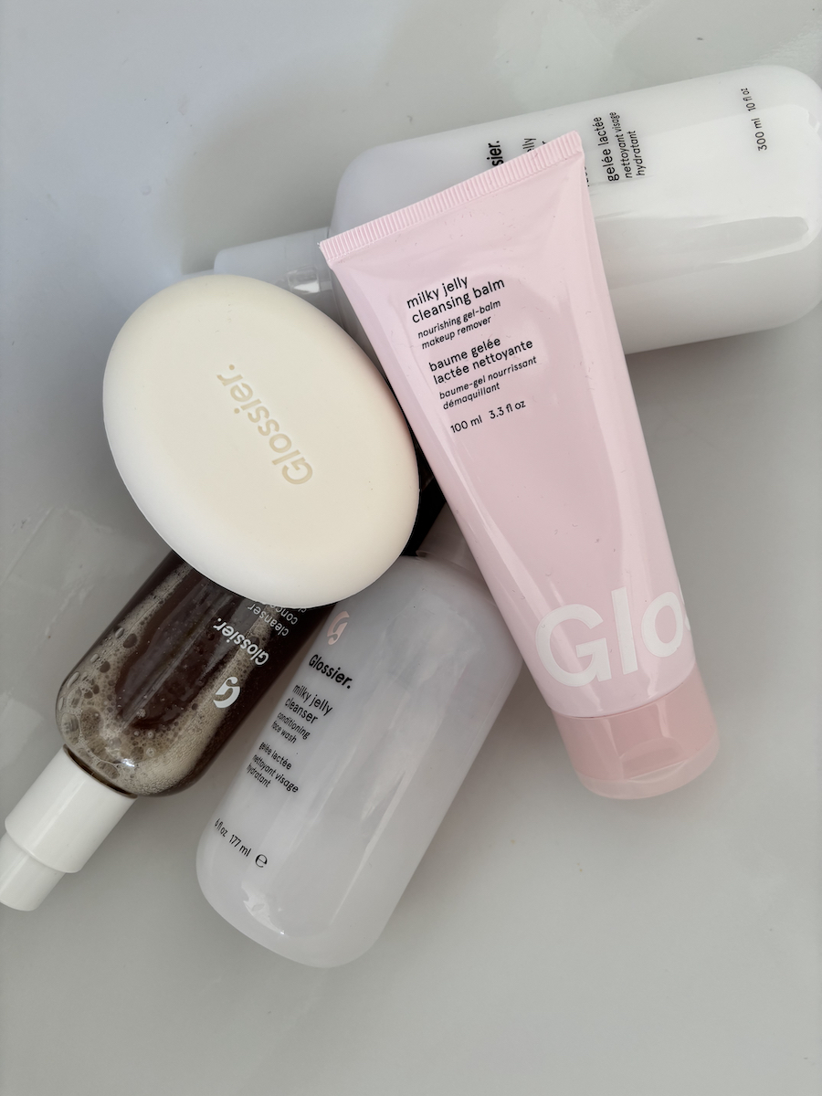 Selection of Glossier cleansers in sink including Glossier Milky Jelly Cleansing Balm