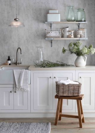 laundry room with open shelves, baskets, flowers and a concrete effect wall