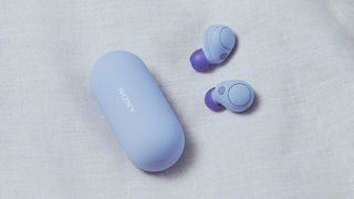 Ecouteurs Sony WF-C700N en couleur lavande sur un tissu