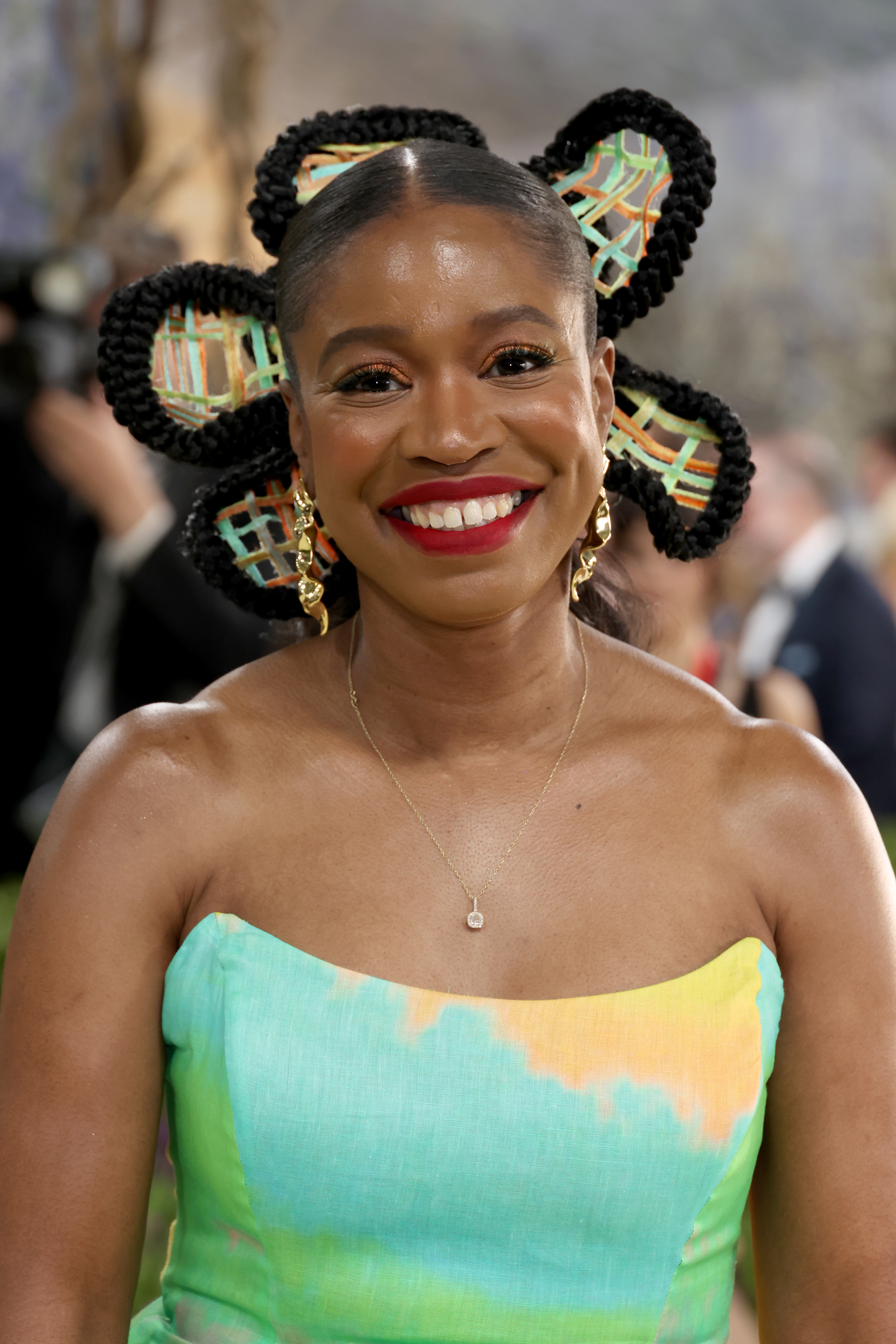a woman with red lipstick and sculptural braids