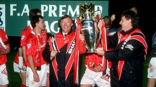 3 May 1993, Manchester - Premiership Football - Manchester United v Blackburn Rovers - Happy Manchester United manager Alex Ferguson holds the Premiership trophy with his assistant Brian Kidd (right) watched by captain Bryan Robson. (Photo by Mark Leech/Offside via Getty Images)