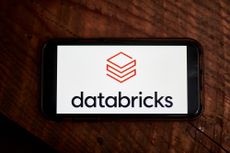 Databricks logo displayed on a smartphone screen with brown wooden background