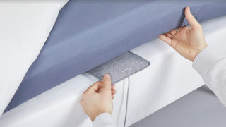 Man putting Withings Sleep Analyzer under a mattress