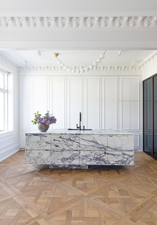 a hidden kitchen with a large floating island marble