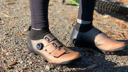 Image shows a rider wearing the Shimano RX8R gravel shoes