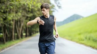 Man looking at watch while running