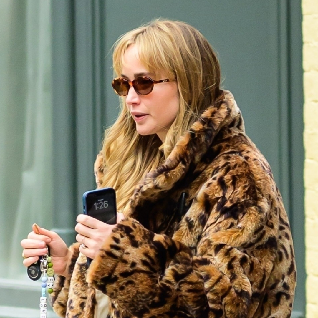 Jennifer Lawrence wearing a leopard-print faux fur coat, wool pants, and turquoise blue ostrich ballet flats