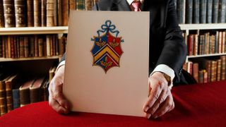 Garter Principal King of Arms and Senior Herald in England, Thomas Woodcock, holds the new Coat of Arms of Catherine Middleton's family at the College of Arms