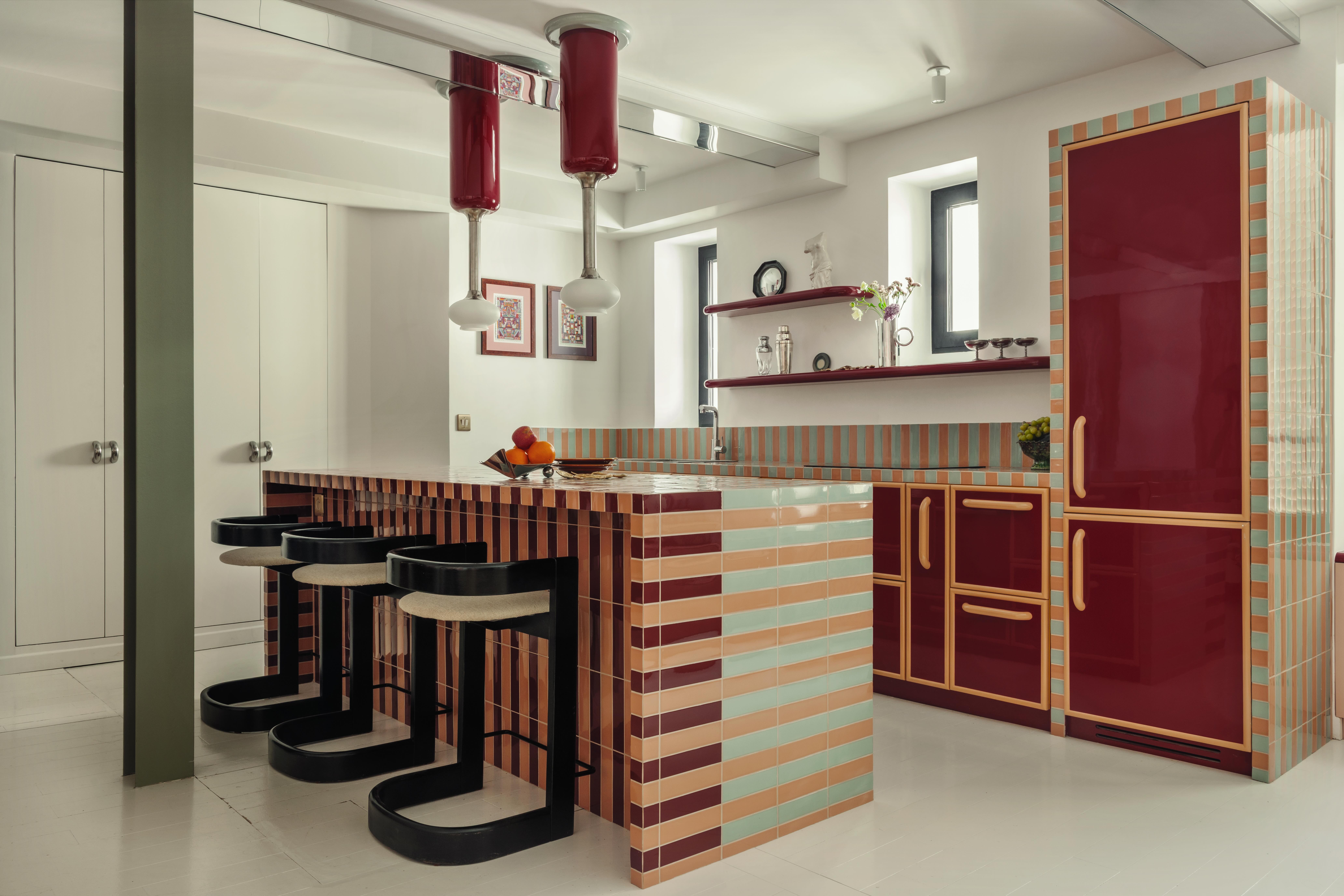 A kitchen adorned with glossy, colorful tiles and surfaces covered in custom lacquer finishes.