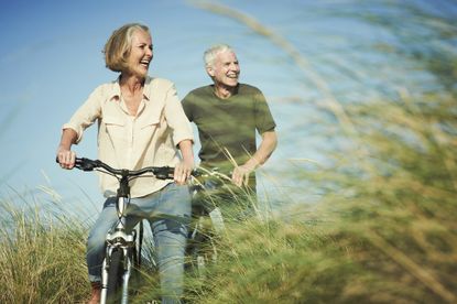 Senior couple enjoying day out on their bicycles - stock photo