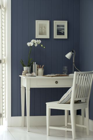 blue shiplap wall home office with white woodwork, white desk and white painted floorboards