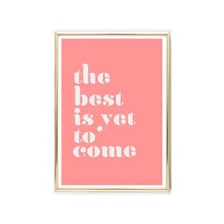 A pink wall art print that says 'the best is yet to come'