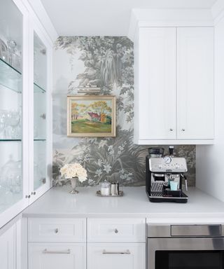 White shaker kitchen with gray wallpaper and coffee machine