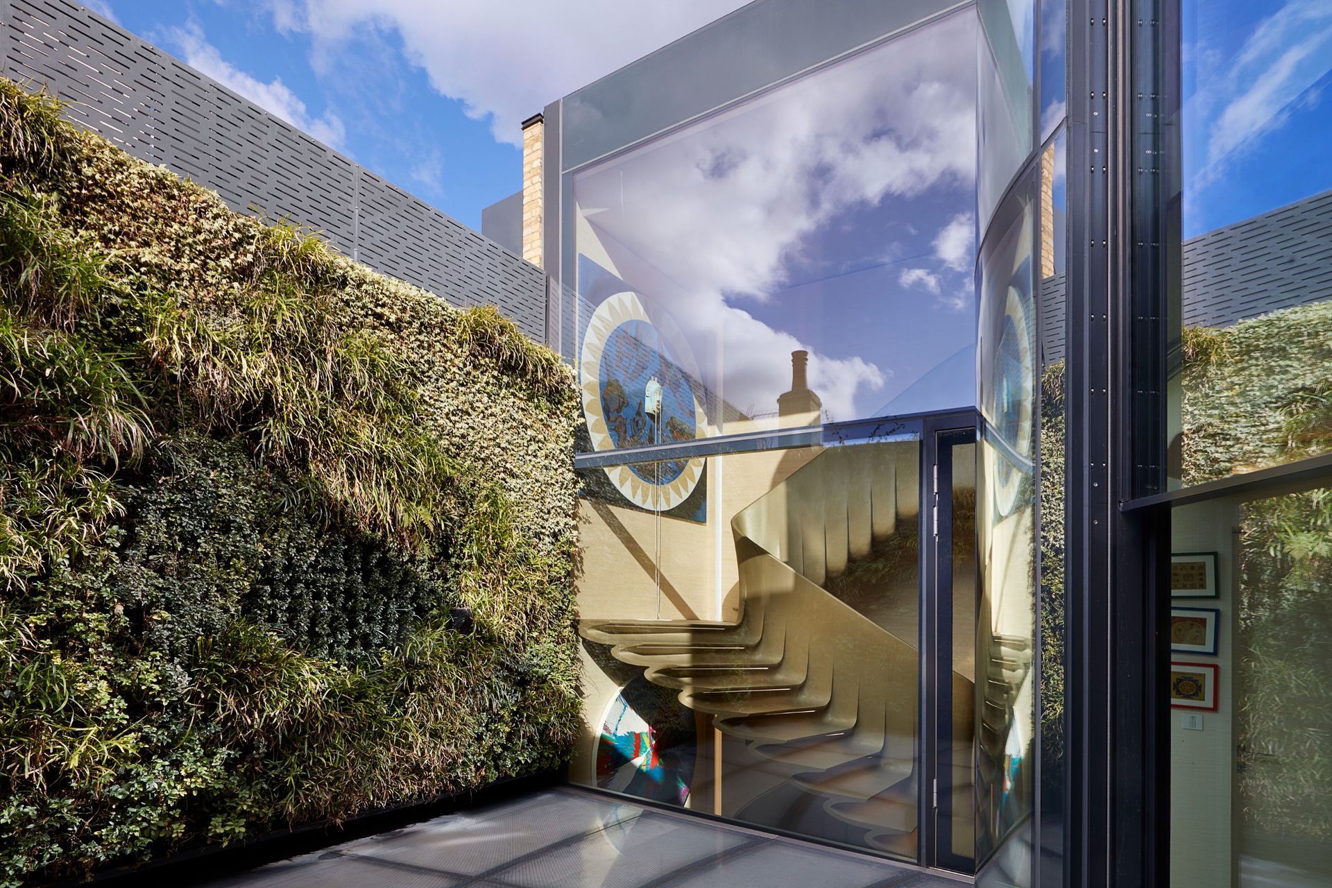 The terrace adjoins the glazed stairwell and has a planted wall