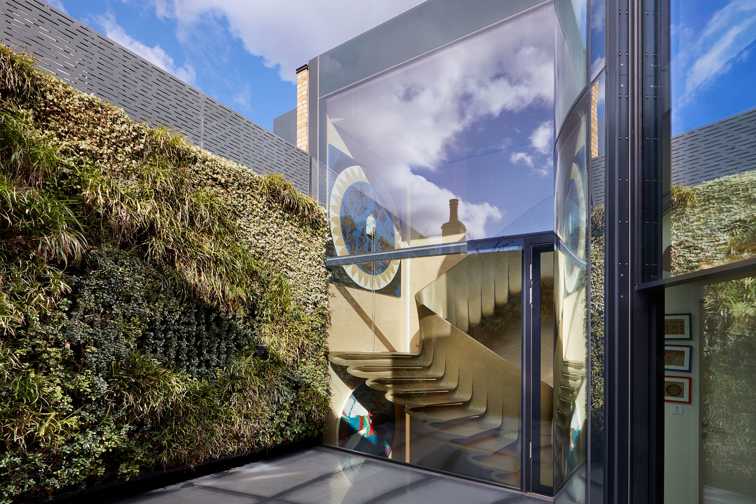 The terrace adjoins the glazed stairwell and has a planted wall