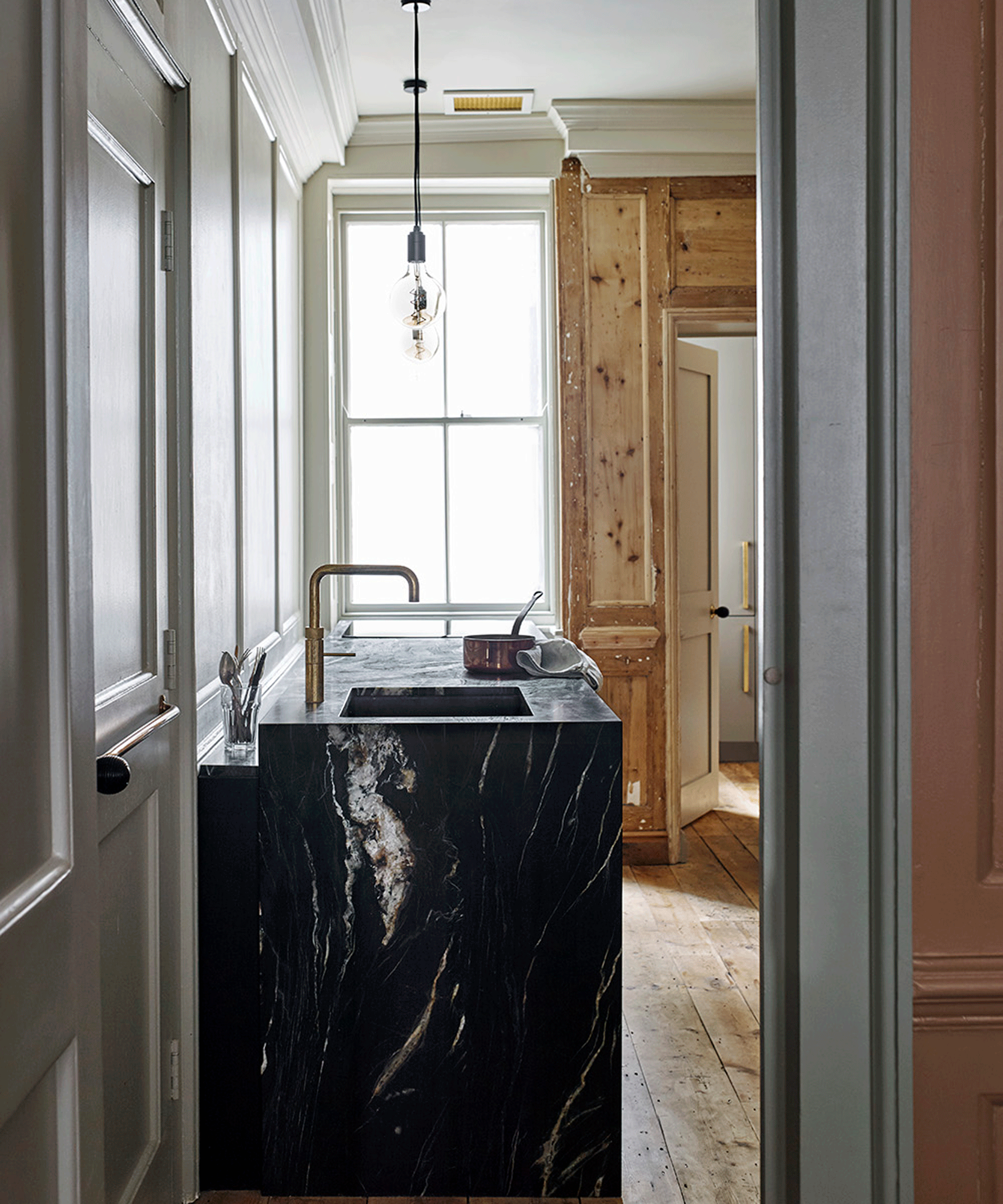 A doorway looking into a kitchen with a black marble surface