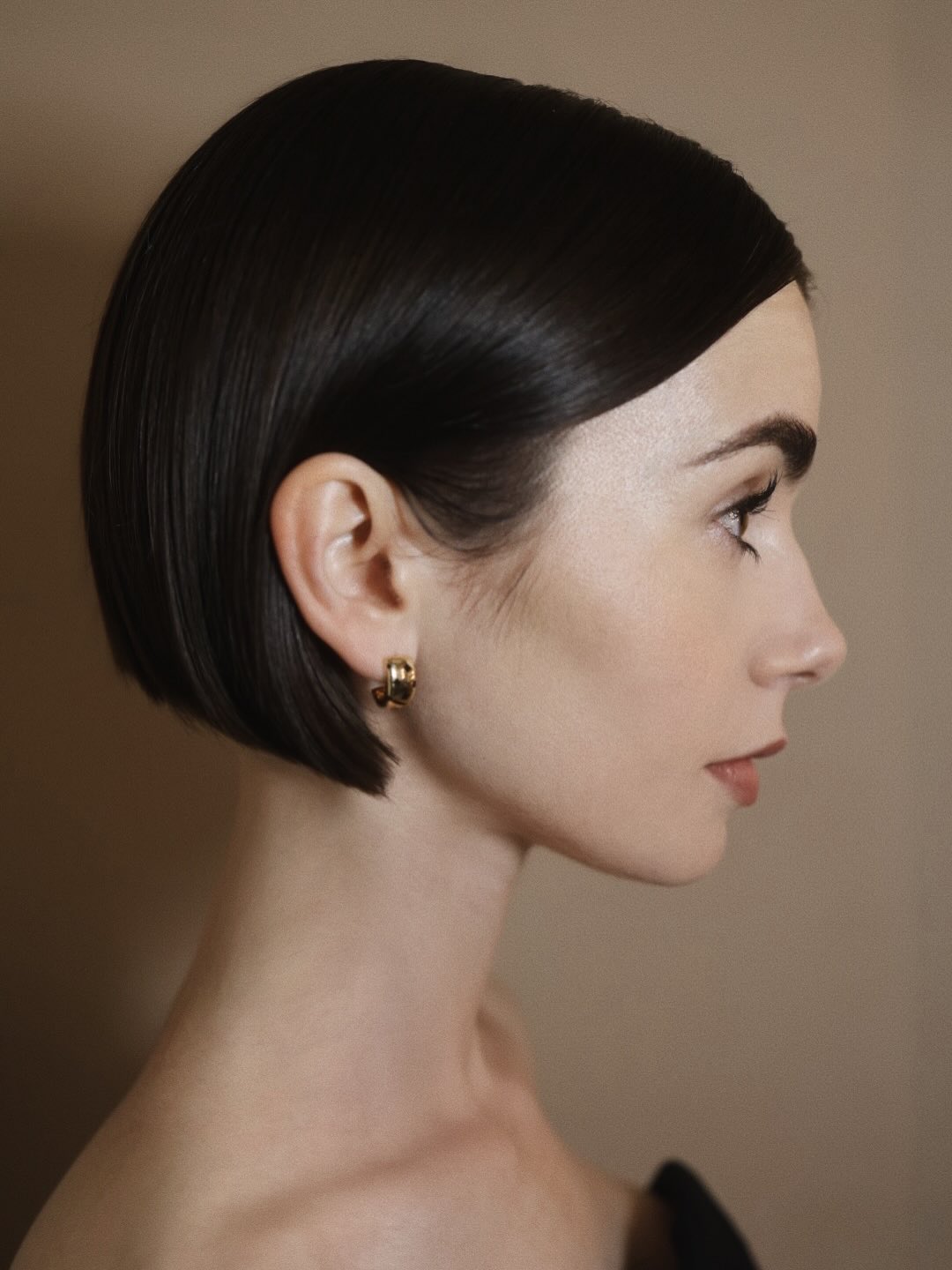 An image of Lily Collins at a SAG-AFTRA event for Emily In Paris with a micro bo.b