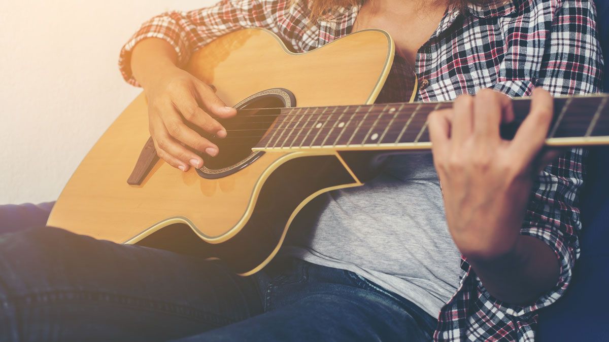 Close up of a woman playing an acoustic guitar