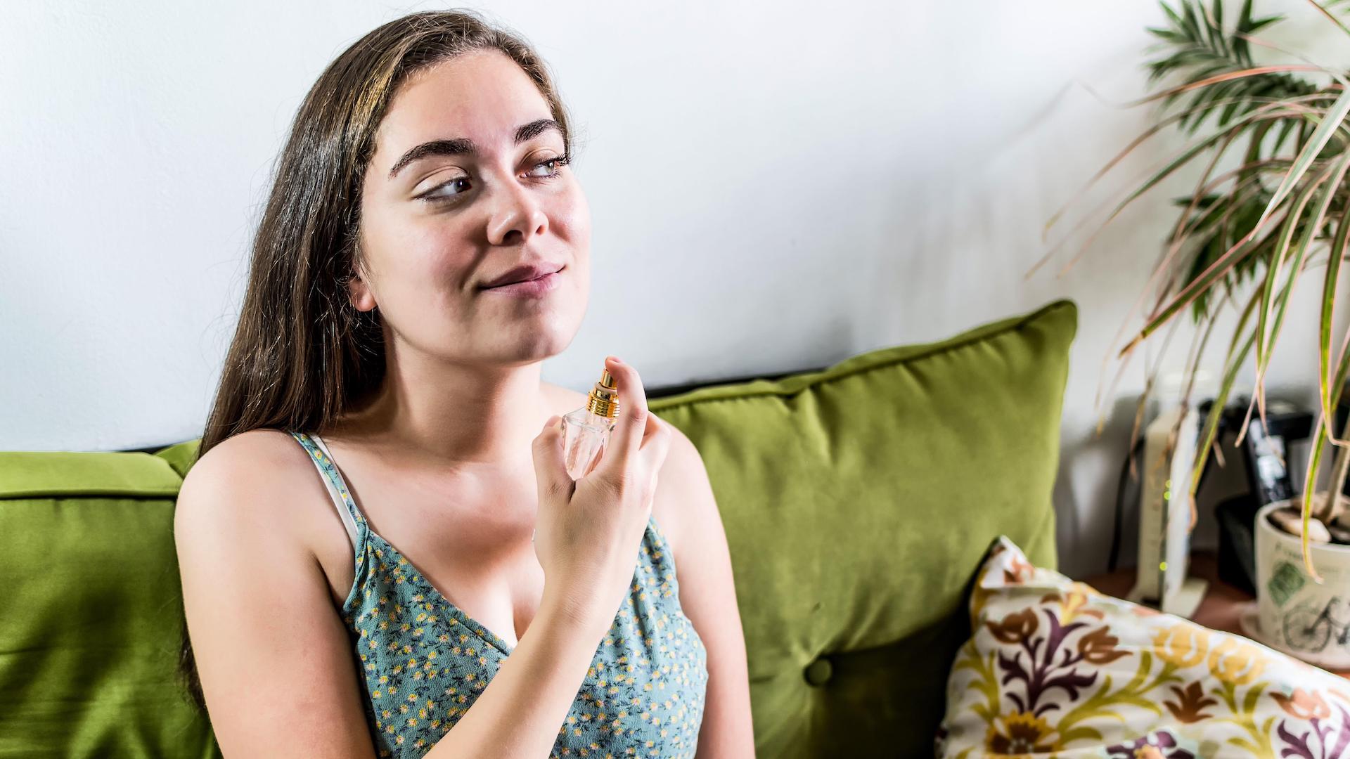 Woman putting on perfume
