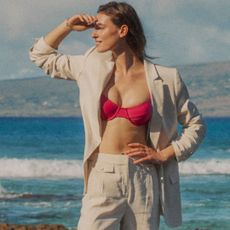 editorial image of woman wearing j.crew 1983 Underwire Bikini Top and white suit on the beach looking away