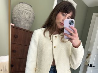 Girl taking a mirror selfie wearing a white blazer