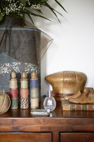 Vintage threads and sewing accessories displayed on bookshelf