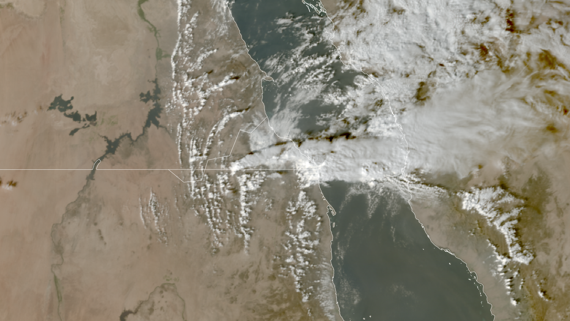 An aerial view of smoky material above two landforms separated by a river.