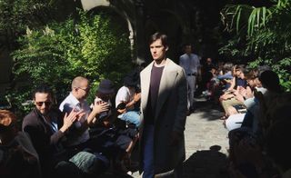 Trousers were pleated and tapered at the ankle to give volume, while long and large trench coats came belt-less for ease