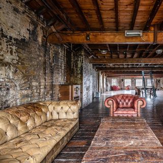 warehouse with wooden floor and sofa and bricked wall