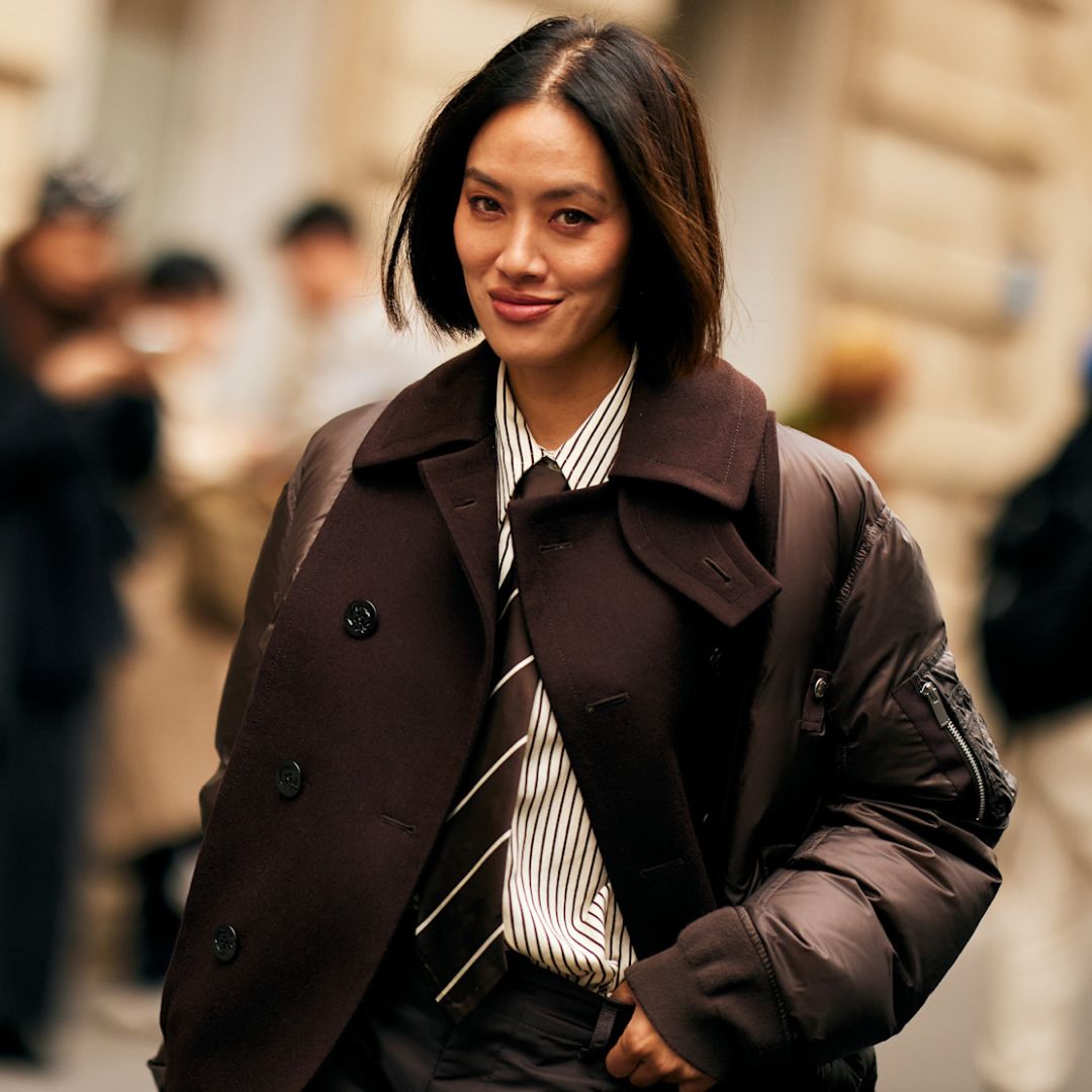 fashion week attendee wearing striped shirt, tie looking at camera