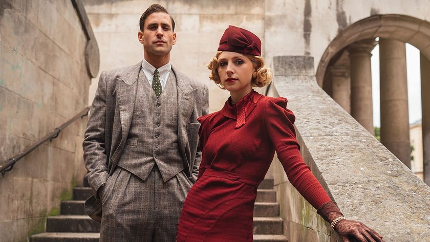 Stylishly dressed yet somber, Neville Strange (Oliver Jackson-Cohen) and his ex-wife Audrey (Ella Lily Hyland) stand on the stone steps of their childhood home in BBC One miniseries Towards Zero.