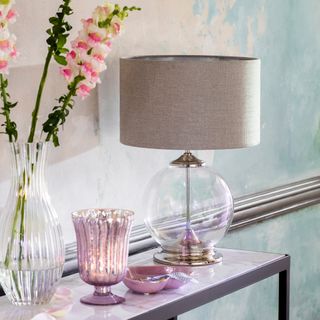 glass vase with pink flower and table lamp