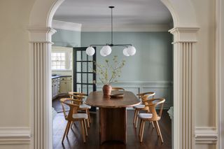 A dining space with beige arches and blue walls