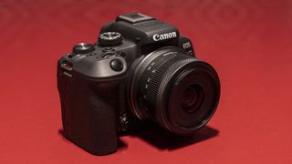 The Canon EOS R10 camera on a red surface