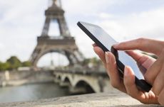 Woman using her Mobile Phone in front of Eiffel Tower