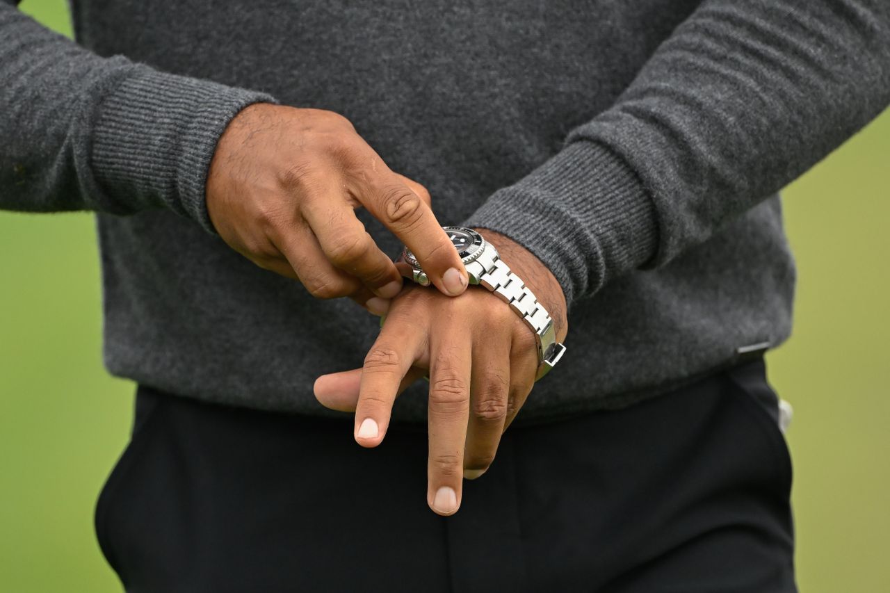 Tiger Woods puts on his watch
