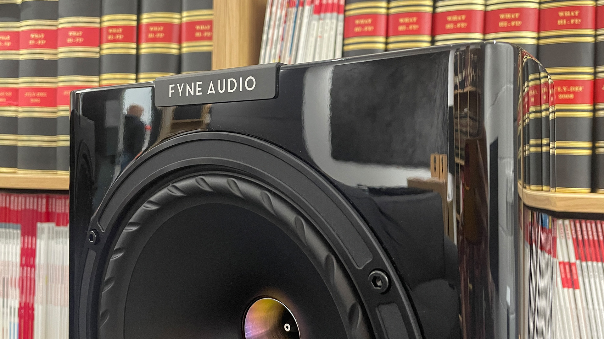 Fyne Audio F701SP standmount speakers close up on mid/bass unit in front of bookcase