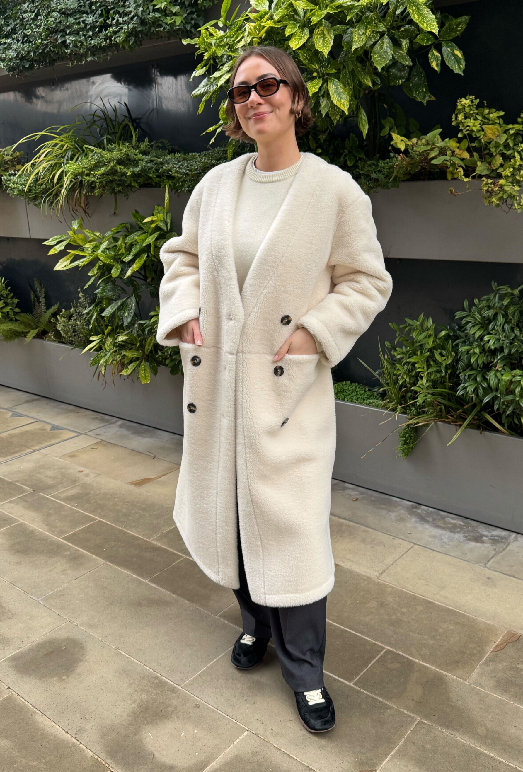 An editor from Who What Wear UK modelling a teddy coat