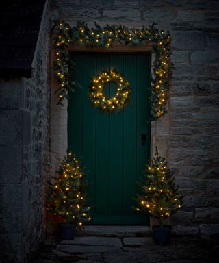 light-up wreath trees and garland from Cox & Cox around green door