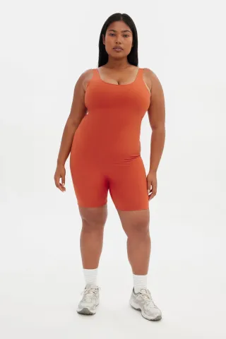 model wears short unitard in orange