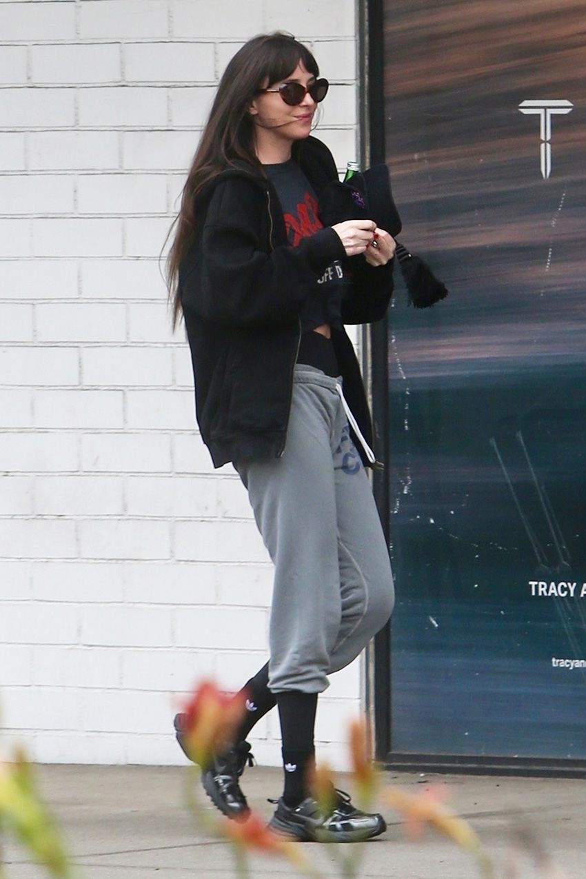 Dakota Johnson wearing sweatpants over leggings